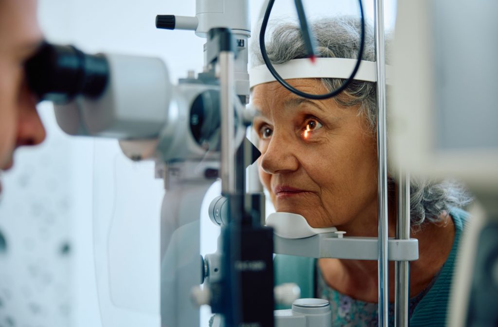 A woman having her eyes examined with a slit lamp at the eye doctor.