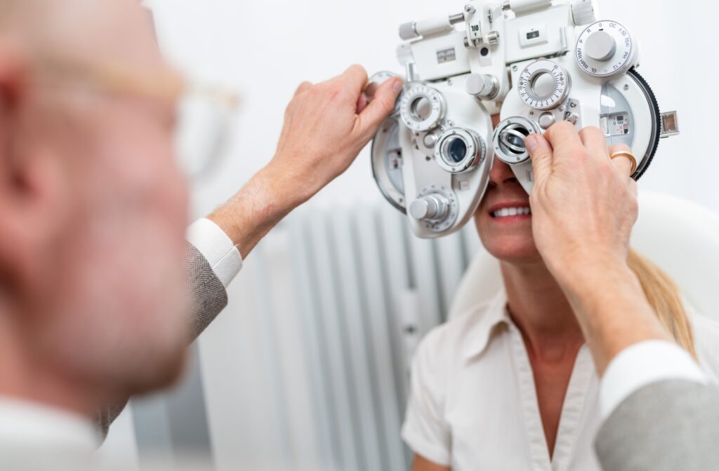 An eye doctor adjusts the phoropter during a patient's refraction test.