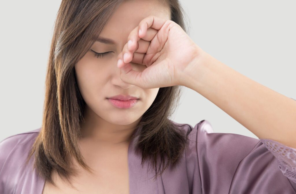 A woman rubbing her eyes because she is tired.