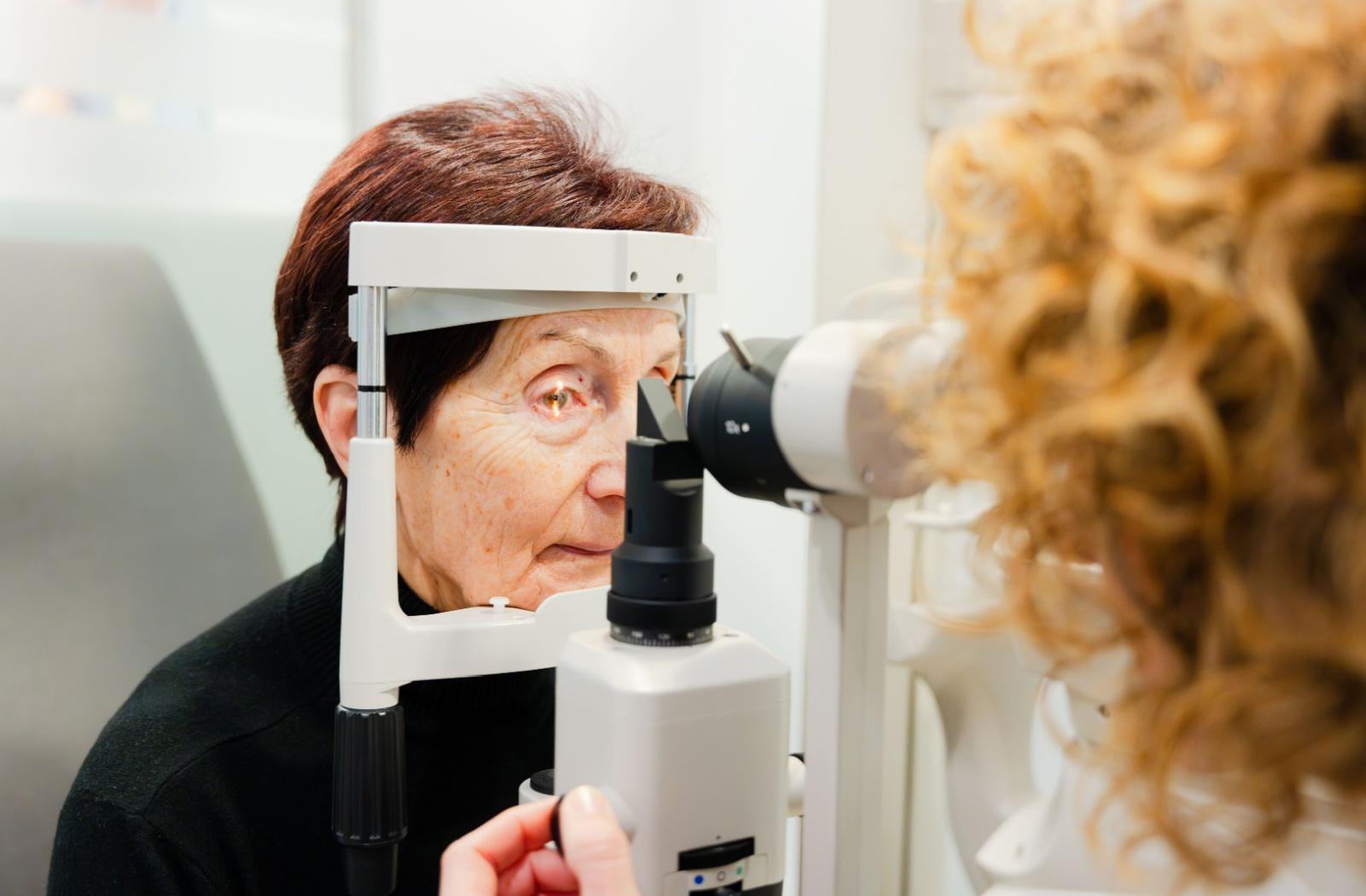 A person with cataracts getting an eye exam from an optometrist.